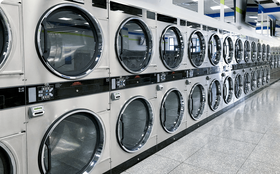 Rows of industrial dryers in a laundromat.